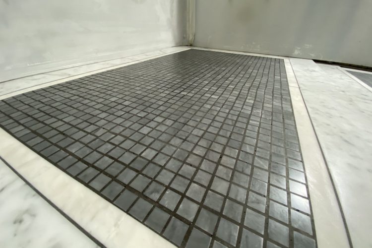 Freshly polished black marble mosaic floor in London bathroom - professional restoration result Freshly polished black marble mosaic bathroom floor in London – professionally restored to brilliant, high-gloss finish by specialist team.