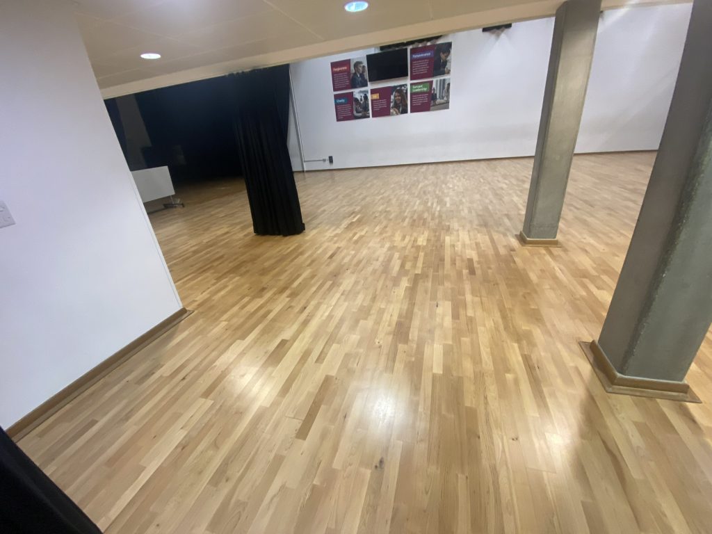 Freshly sanded school hall floor in London around SW20 – professionally restored to smooth, even surface ready for commercial-grade lacquer application.